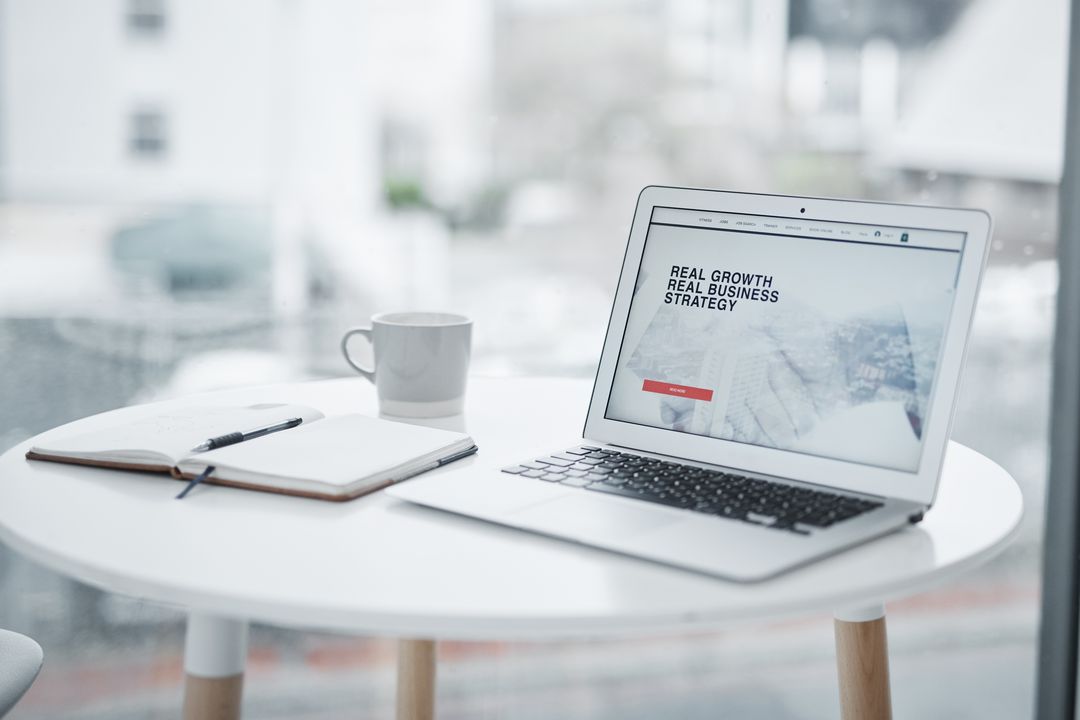 Laptop mit geöffneter Website auf einem runden Tisch