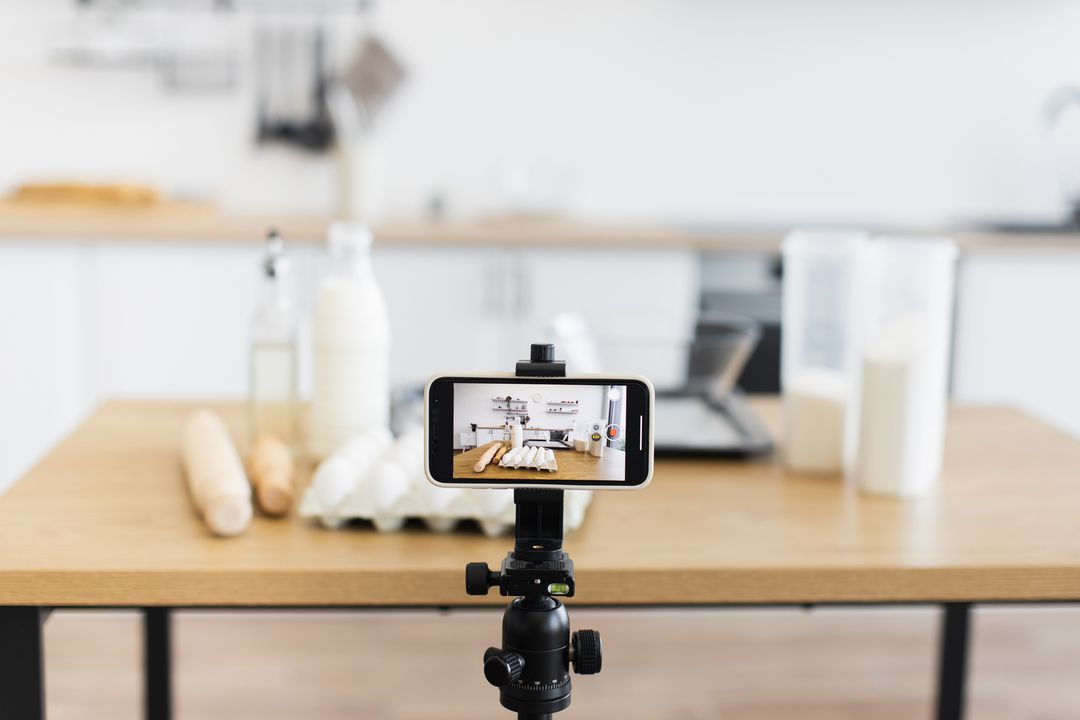 Smartphone auf einem Stativ filmt in einer Küche