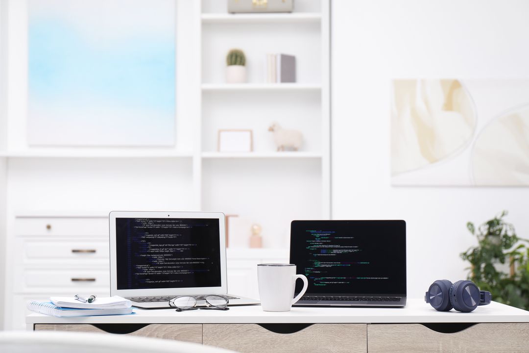 Heller Arbeitsplatz mit Laptop und Bildschirmen